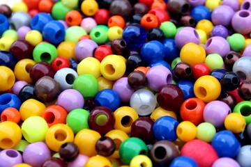 Fototapeta na wymiar The texture of bright ri different sizes of beads for needlework.