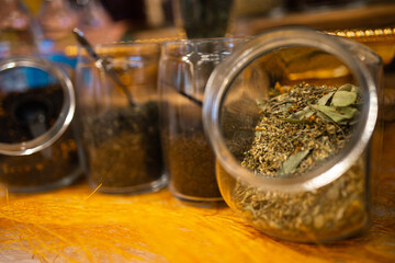 A glass jar with dried tea leaves.