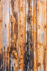 Old scratched wooden background with pieces of old paint and screws nails. Rustic obsolete boards of wall, door or floor. Selective focus