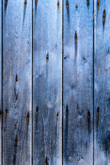 Old blue scratched wooden background with pieces of old paint and screws nails. Rustic obsolete boards of wall, door or floor. Selective focus
