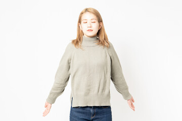 深呼吸をしているセーターを着た若い女性