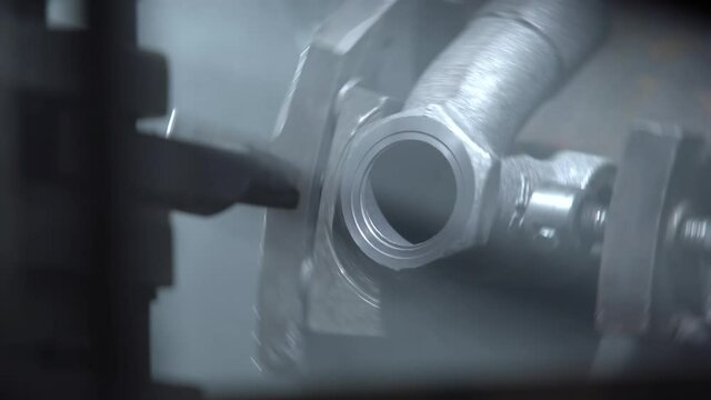 Metal cutting machines work in a large workshop. Machining shaft on lathe. Metalworking. Turner working on machine. Lathe work. Modern processing technology of detail. Detail shot close up.