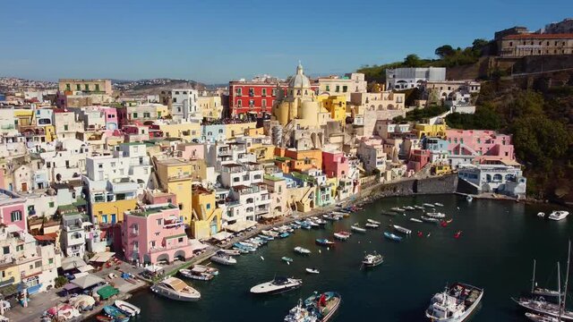 Aerial drone footage of the Procida typyical old town with its fisherman harbor in the bay of Napoli in Italy. Shot with an upward and tilt town motion. 
