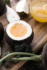 Organic raw Black radish with honey on wooden table. Homemade cough medicine. Folk remedy for...