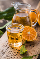 Traditional homemade orange liqueur limoncello and fresh citrus on a wooden table.