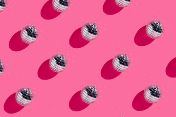 Creative Christmas party pattern made with shiny disco balls on vibrant pink background. Minimal Xmas or New Year eve celebration concept. Minimal winter holidays idea. Contemporary wallpaper.	