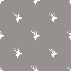 seamless winter pattern with silhouette of deer head with antlers.