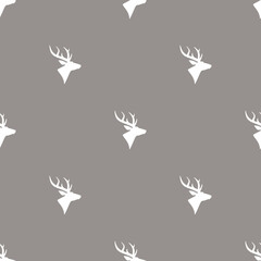 seamless winter pattern with silhouette of deer head with antlers.
