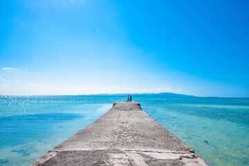 Beautiful clear blue sky and the blue ocean at Taketomi island Pier, Okinawa, Japan. Pier with the...