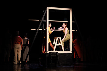 Actors and actresses perform a modern performance on the stage of the theater.