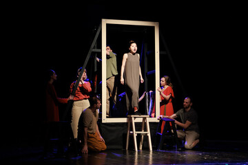 Actors and actresses perform a modern performance on the stage of the theater.