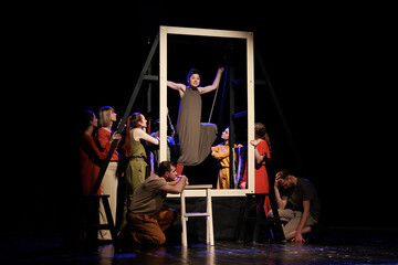 Actors and actresses perform a modern performance on the stage of the theater.