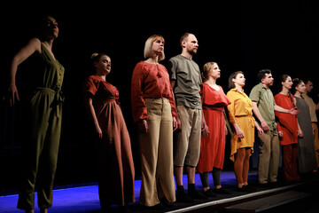 Actors and actresses perform a modern performance on the stage of the theater.