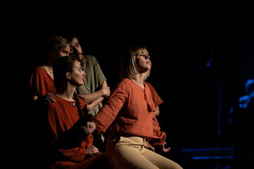 Actors and actresses perform a modern performance on the stage of the theater.