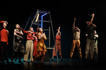 Actors and actresses perform a modern performance on the stage of the theater.