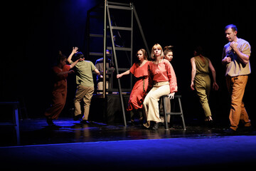 Actors and actresses perform a modern performance on the stage of the theater.