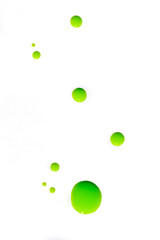 Attractive bright abstract background: drops of luminescent green varnish on a white surface