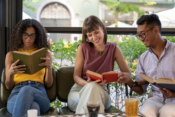social and cultural inclusion in a literary cafeteria, group of young students read books and...
