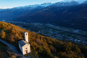 autumn aerial view of the small church of Santa Maria, near Carnale in Valtellina, Italy
