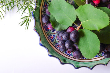 shadberry on twigs with leaves on a plate