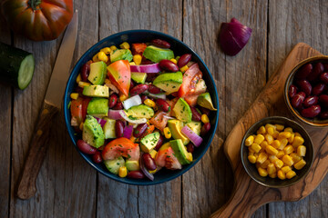 Fototapeta na wymiar Avocado salad with other vegetables, tomatoes and corn. Healthy food
