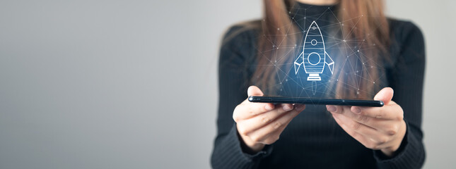 Businesswoman touching tablet and rocket