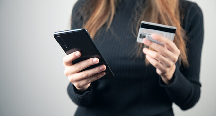 woman is holding credit card and smart phone