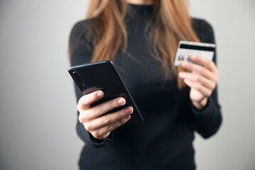 woman is holding credit card and smart phone