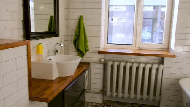 Bathroom interior with toilet bowl, mirror with bathtub sink and shower cabin with window and heating radiator