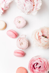 top view of cup of coffee with macarons and flowers 