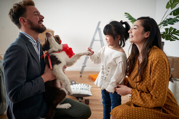 A young family with a dog is enjoying a new home they have just moved in. Home, family, moving