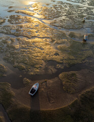 Boats on dry land with sun shining on the mud in Southend on sea, Essex, England, UK