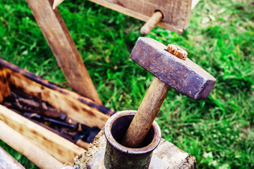 An ancient hammer for forging metal. Fragment of a blacksmith's street workshop. Close-up