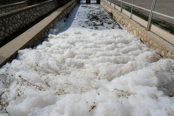 Water pollution. Pollution of a channel caused by surfactants.White foam in a stream kills life....