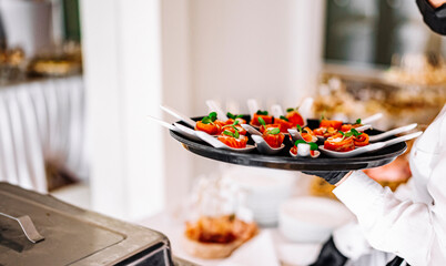woman hands of a waiter prepare food for a buffet table in a restaurant