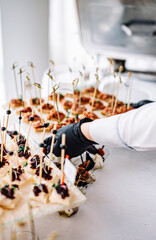 woman hands of a waiter prepare food for a buffet table in a restaurant