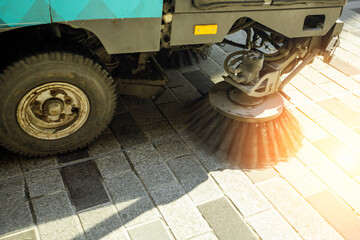 Close-up street sweeper machine cleaning in the morning.