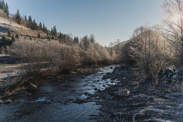 Frosty morning. Hoarfrost in the trees. Mountain river in the village. Ukrainian Carpathian mountains. Autumn in the mountains.