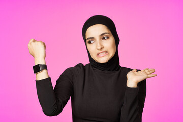 muslim woman with smart watch technology gadget pink background