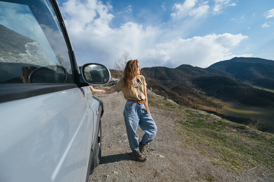 Traveling female sitting on Off-road car in beautiful view of Altai mountain landscape and  asphalt road