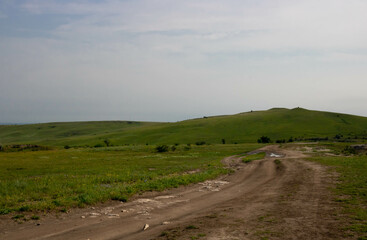 Summer landscape of beautiful green hills and dirt road