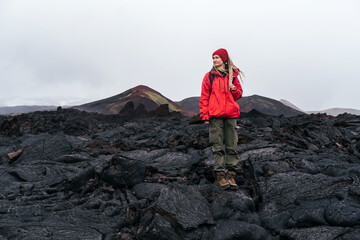 Woman tourist walking on frozen lava after Tolbachik volcanic eruption. Tourism in the land of volcanoes Kamchatka