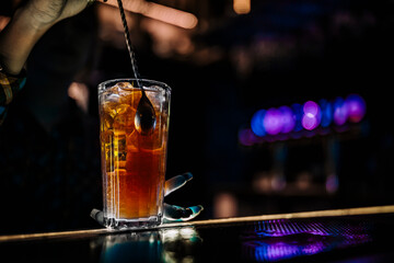 woman bartender hand at the bar or pub to prepare a cocktail Long Island