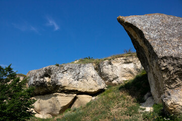 A cliff stone located in a piece of rock isolated against a blue sky background