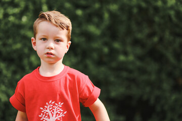 Cute little boy gazing at camera in backyard setting