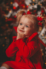 a little girl makes a wish under a Christmas tree 