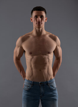 Fit and muscular. Shirtless guy in jeans grey background. Sporting man with fit torso