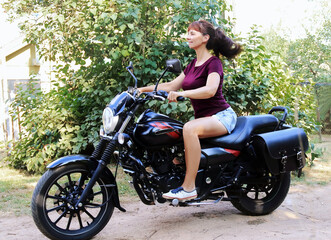 Plakat Woman driving a motorcycle outside the city