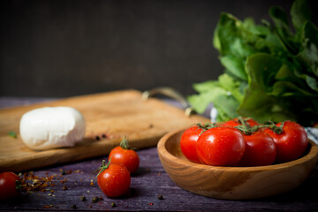 Traditional Italian caprese salad with tomatoes, mazarella cheese and basil on a light marble background in a white old ceramic plate.