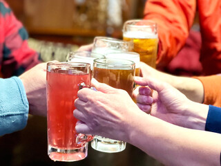 ビールとジュースで乾杯するグループの手 © smile